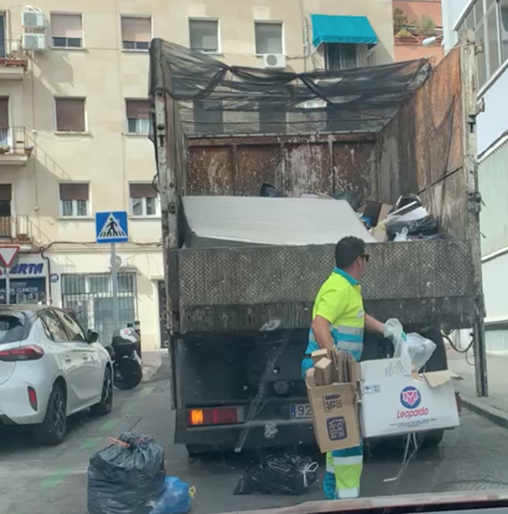 Un operario de Ayuntamiento lanzando toda la basura al camión